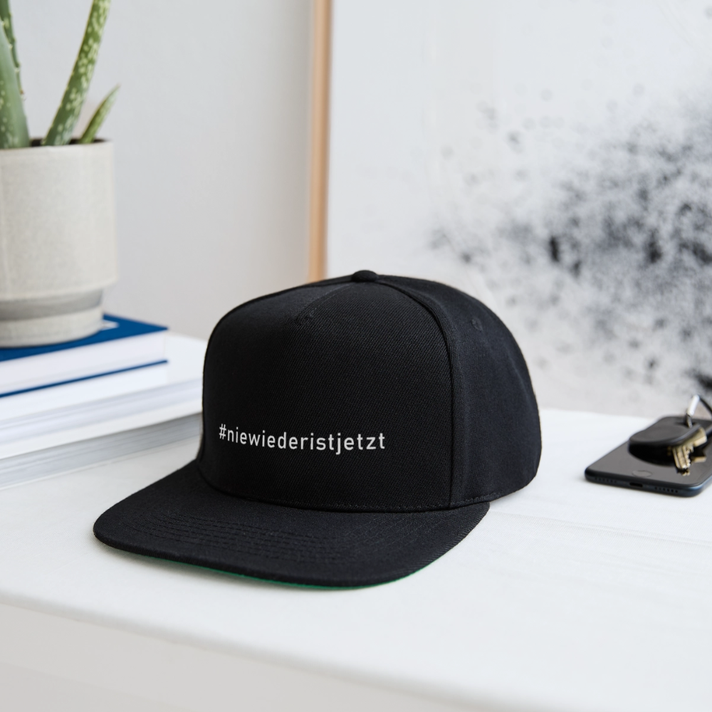 Seitenansicht: Retro-Basecap mit grün abgesetzter Schirmunterseite und Statement-Design

