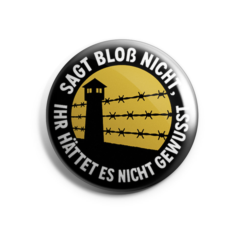 „Runder Button mit gelbem Zentrum und schwarzer Aufschrift ‚Sagt bloß nicht, ihr hättet es nicht gewusst‘.“