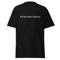 Schwarzes Unisex‑T‑Shirt, Vorder‑ und Rückseite mit weißem Hashtag „#niewiederistjetzt“.