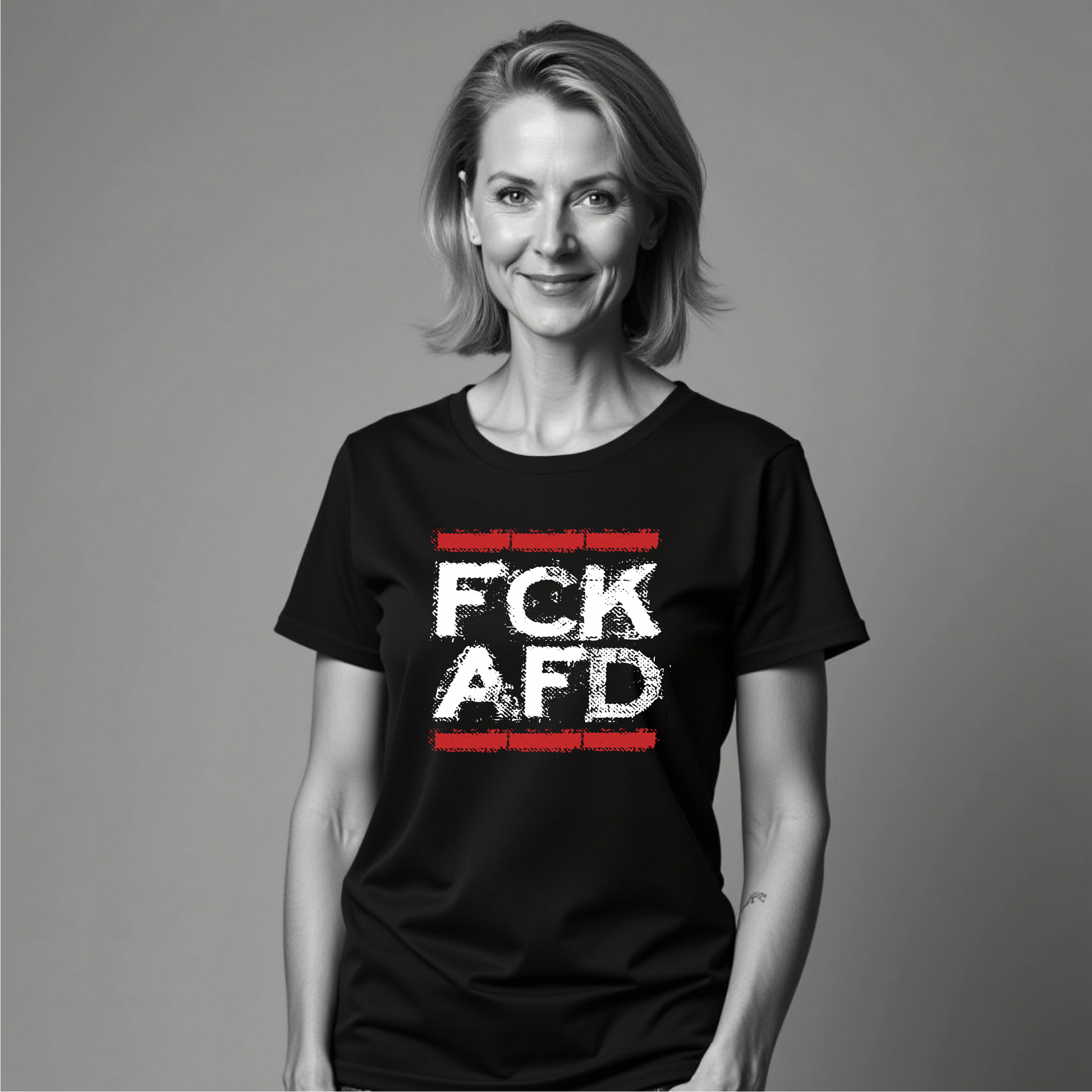 Frau trägt FCK AFD T‑Shirt Damenfit mit rotem Backstein‑Hintergrund

