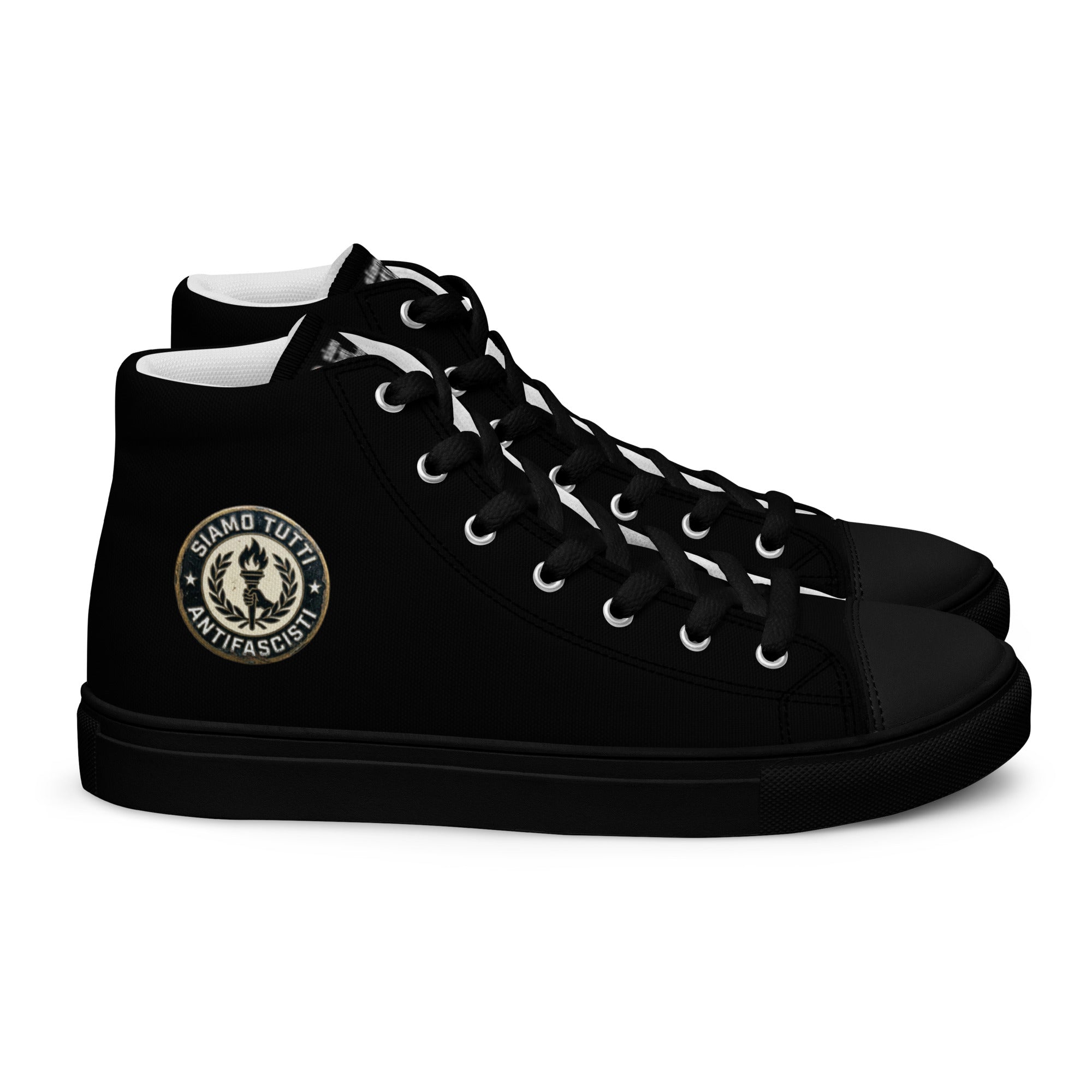 „Schwarze High‑Top‑Leinenschuhe für Herren mit weißer Sohle. Auf der Außenseite befindet sich ein rundes Emblem mit einer stilisierten Fackel, Lorbeerkranz und dem Text ‚Siamo tutti antifascisti‘.“

