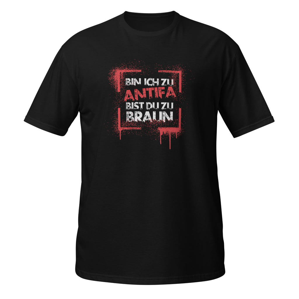 Schwarzes Unisex‑T‑Shirt mit einem rechteckigen, rot‑weißen Graffiti‑Print. Darin steht in gesprühter, leicht verlaufender Schrift: „BIN ICH ZU ANTIFA BIST DU ZU BRAUN“. Die Typografie wirkt wie gesprayt, mit Tropfen‑ und Drip‑Effekten.


