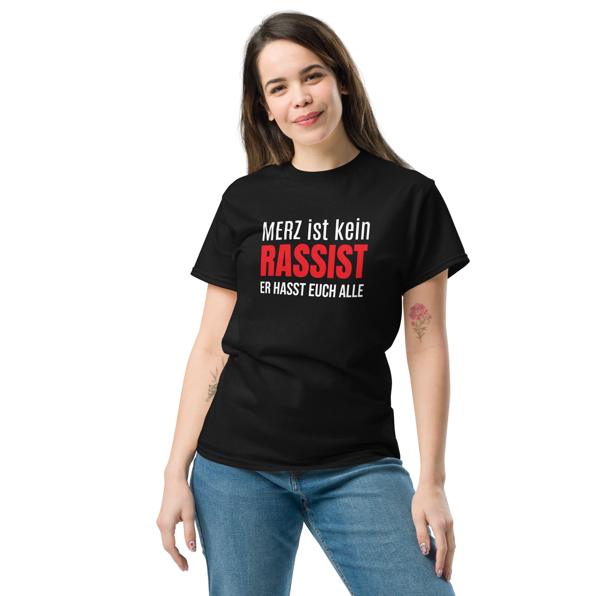 Frau trägt schwarzes Unisex T‑Shirt mit dem typografischen Aufdruck ‚Merz ist kein Rassist, er hasst auch alle‘.